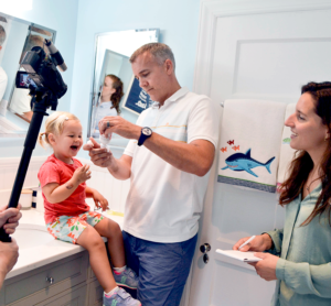 Design researcher observing father giving his daughter oral medication.